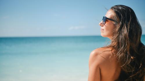 A woman in sunglasses looking at the sea