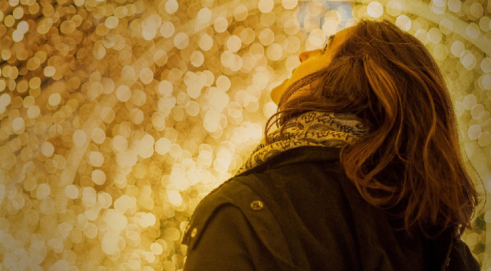 A young woman looking up at the illumination
