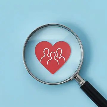 Red paper heart with the outline of three people underneath a magnifying glass on a blue background