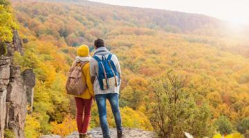Two people standing on a rock looking in a distance