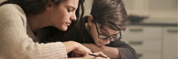 Mother and son writing in a book