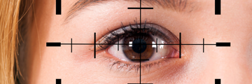 An eye of a young woman in the camera focus.