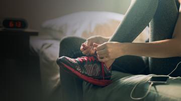 A young woman doing up her shoelaces