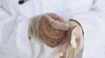 healthcare professional putting on medical gloves