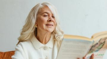 An older woman flicking through a book