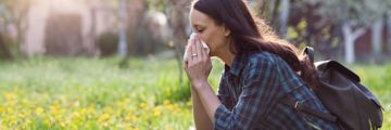 A young woman sneezing